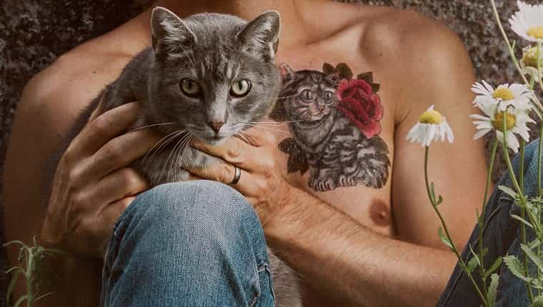 Hombre con tatuaje de gato y su gato mascota