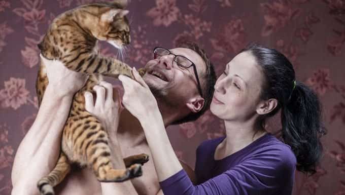 pareja sosteniendo un gato alto